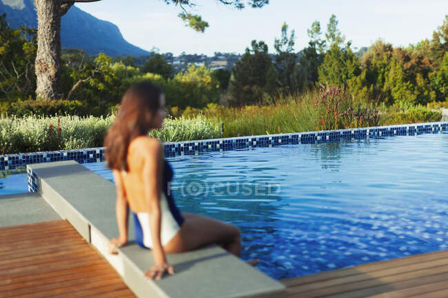Mulher de fato de banho relaxante na piscina idílica e tranquila — Fotografia de Stock