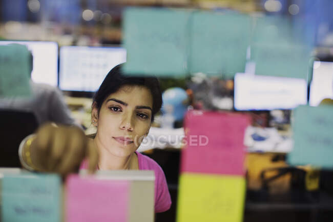Виділена бізнес-леді з клейовими нотатками планування в офісі — стокове фото