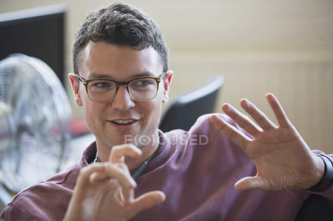 Empresário sorridente gesticulando, explicando — Fotografia de Stock