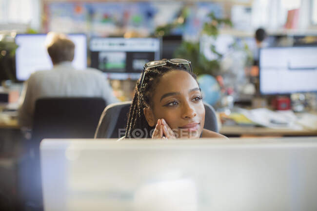 Задумчивая, спокойная деловая женщина за компьютером в офисе — стоковое фото