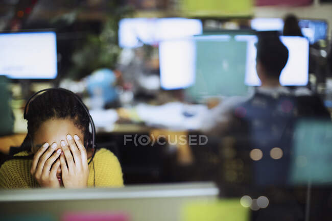 Fatiguée, femme d'affaires stressée avec la tête dans les mains à l'ordinateur au bureau — Photo de stock