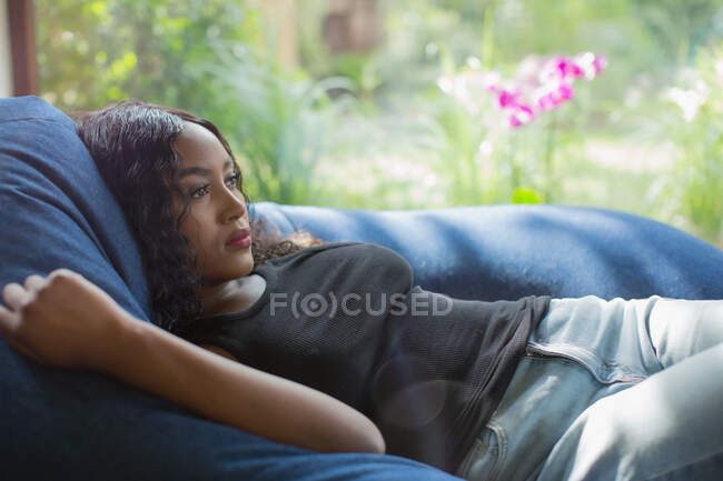 Jeune femme sereine se relaxant dans une chaise beanbag — Photo de stock