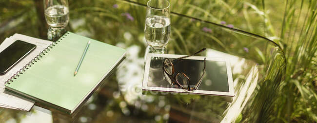 Tableta digital y lentes en la mesa de cristal - foto de stock