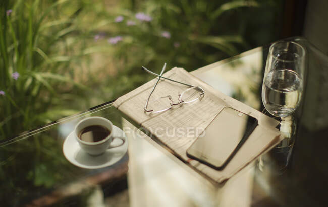 Smartphone e giornale di borsa sul tavolo con caffè — Foto stock