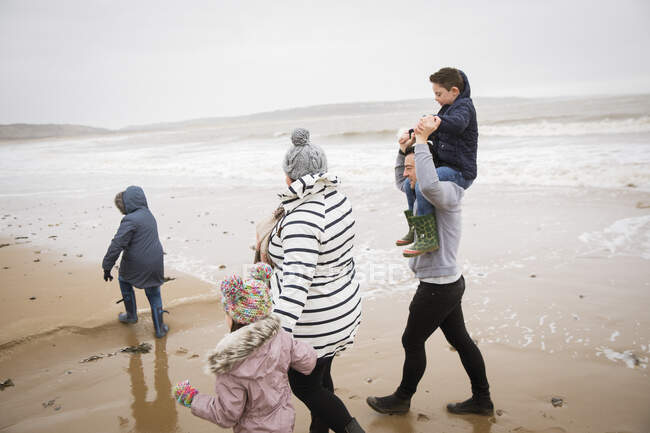 Familia caminando en invierno océano playa - foto de stock
