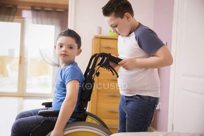 Ritratto ragazzo con sindrome di Down in sedia a rotelle — Foto stock