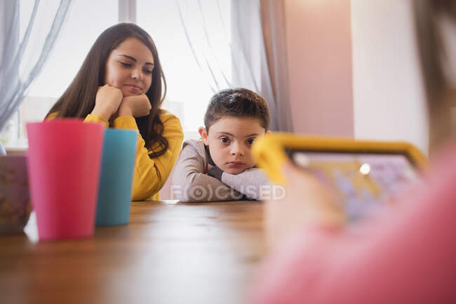 Boy with Down Syndrome at dining table with sister — Stock Photo
