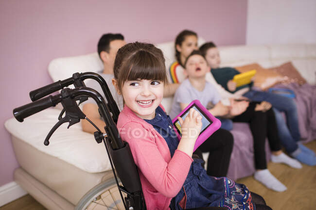 Happy fille handicapée en fauteuil roulant en utilisant une tablette numérique — Photo de stock