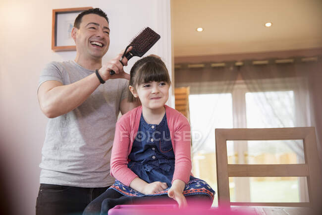 Pai escovar o cabelo da filha com Síndrome de Down — Fotografia de Stock