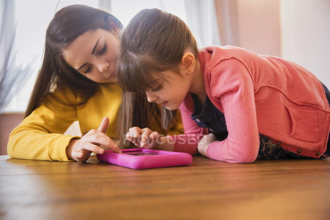 Adolescente y hermana con síndrome de Down usando tableta digital - foto de stock