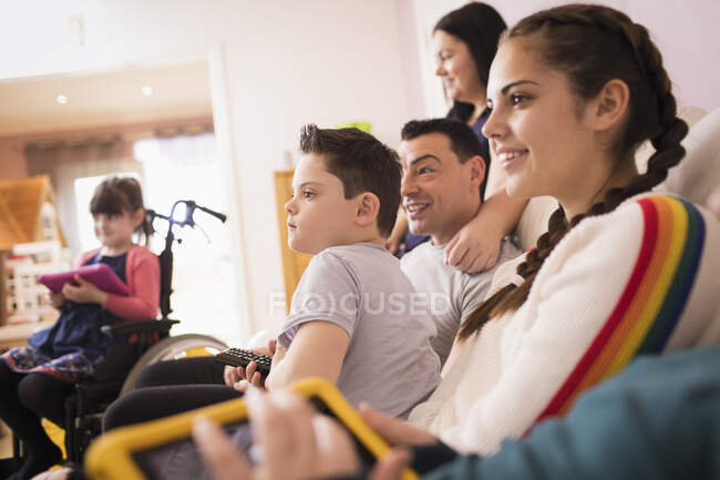 Glückliche Familie vor dem Fernseher auf dem Wohnzimmersofa — Stockfoto