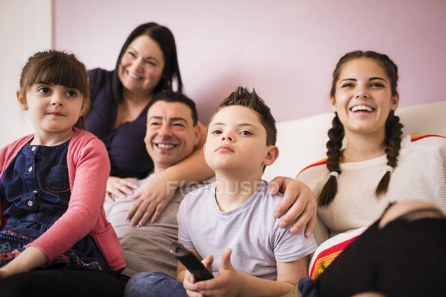 Familia feliz viendo la televisión en el sofá - foto de stock