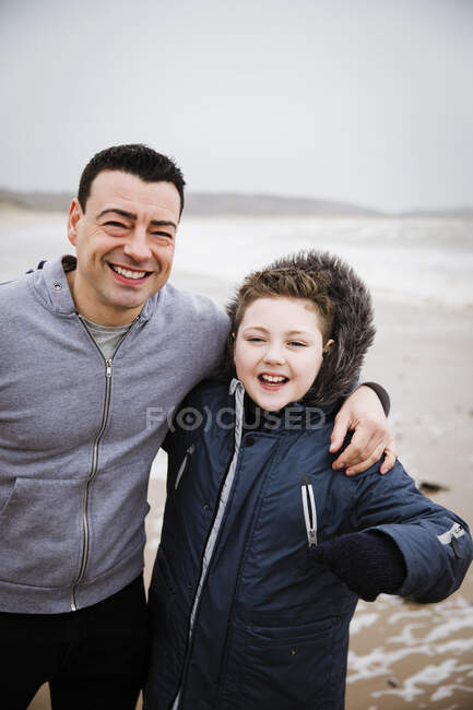 Portrait happy father and son on beach — Stock Photo