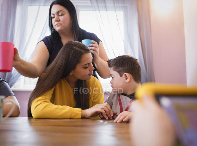 Menino com Síndrome de Down conversando com a irmã na mesa de jantar — Fotografia de Stock