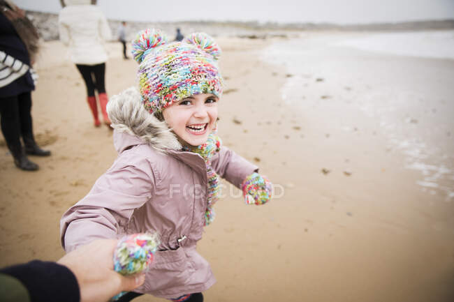 Retrato menina despreocupada feliz em roupas quentes correndo na praia de inverno — Fotografia de Stock