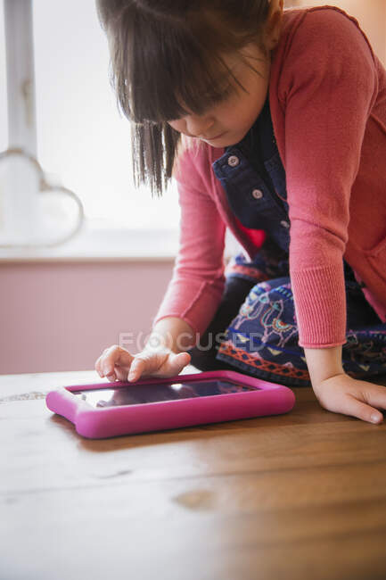Menina usando tablet digital à mesa — Fotografia de Stock