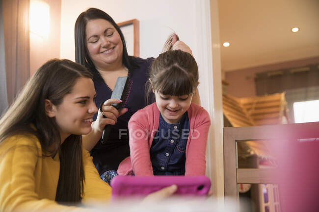 Щаслива мати чистить дочка волосся — стокове фото