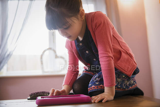 Chica curiosa usando tableta digital - foto de stock