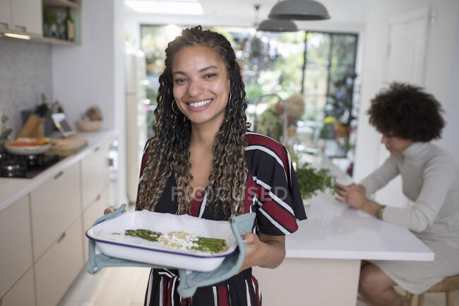 Портрет усміхненої впевненої молодої жінки, що готує на кухні — стокове фото