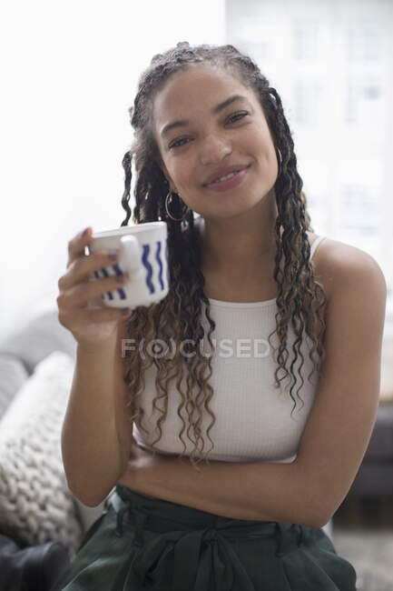 Retrato feliz de la mujer joven que bebe café - foto de stock