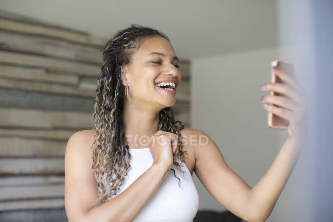 Happy young woman video chatting with smart phone — Stock Photo
