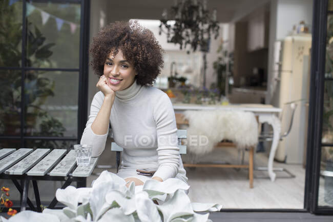 Portrait happy young woman on patio — Stock Photo
