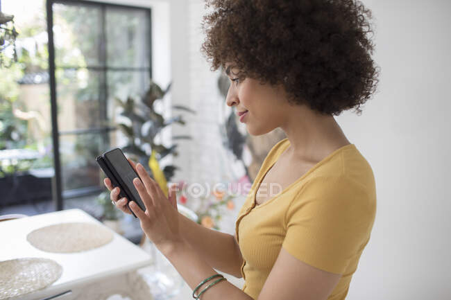 Mulher jovem mensagens de texto com telefone inteligente — Fotografia de Stock