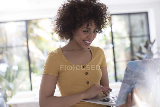 Smiling young woman using laptop — Stock Photo