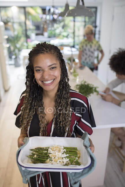 Portrait happy woman cooking asparagus in kitchen — Stock Photo