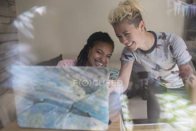 Happy young female entrepreneurs working at laptop — Stock Photo