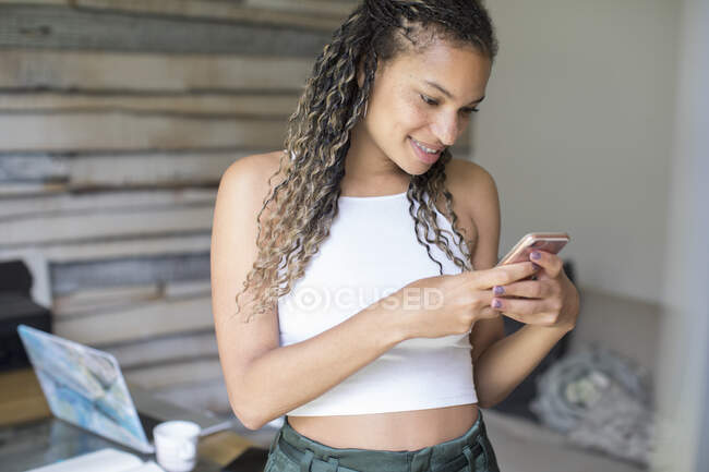 Jeune femme textos avec téléphone intelligent — Photo de stock