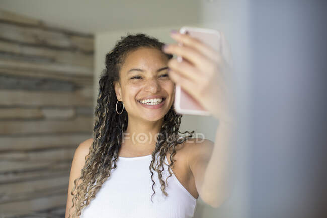 Happy young woman taking selfie with camera phone — Stock Photo