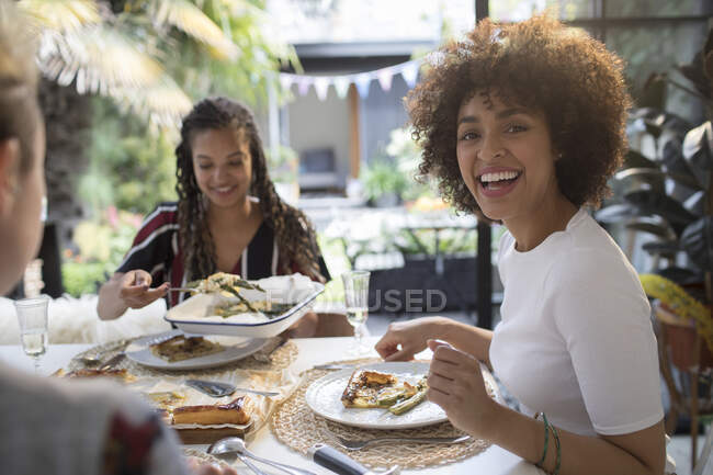 Ritratto felice giovane donna mangiare pranzo con gli amici a tavola — Foto stock