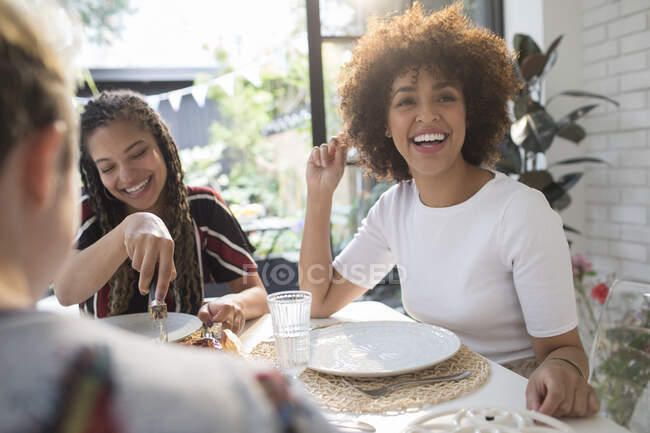Felice giovani donne amici godendo il pranzo al tavolo da pranzo — Foto stock