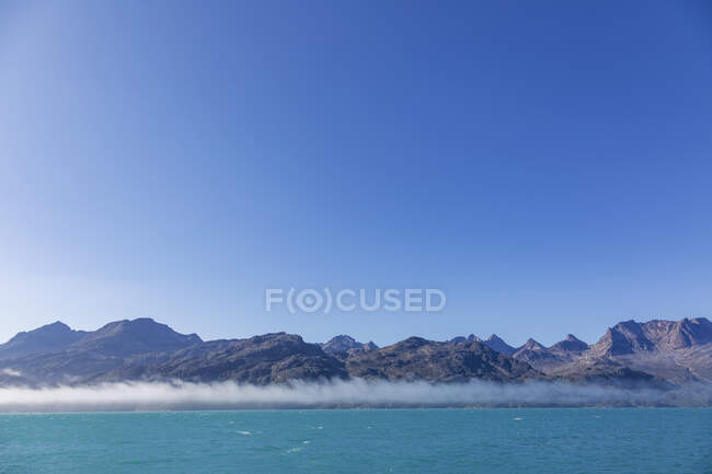 Blue sky over majestic mountain landscape and ocean Greenland — Stock Photo