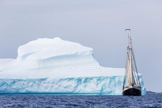 Navio que navega ao longo do majestoso iceberg no Oceano Atlântico Groenlândia — Fotografia de Stock