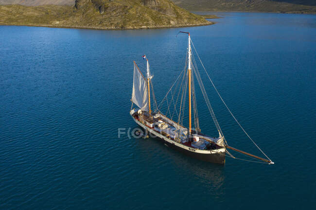Barco en la bahía en el soleado océano azul Groenlandia - foto de stock