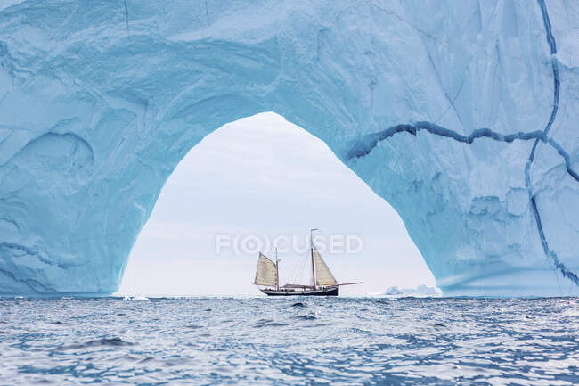 Корабель пливе через величну арку айсберга Ґренландія. — стокове фото