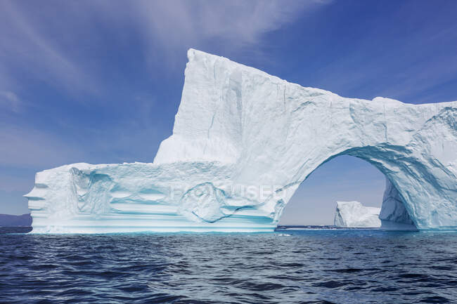 Majestuoso arco de iceberg sobre el soleado Océano Atlántico Groenlandia - foto de stock