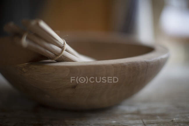 Close up bundled wooden spoons in bowl — Stock Photo