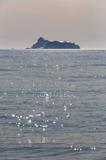 Iceberg in distance on sunny blue Atlantic Ocean Greenland — Stock Photo