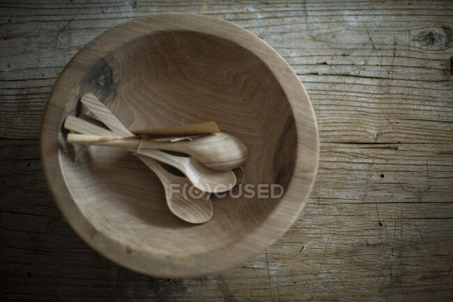 Wooden bowl and spoons on rustic surface — Stock Photo