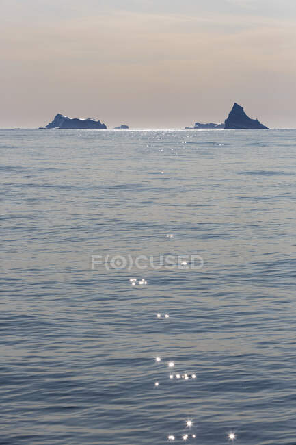 Icebergs em distante no ensolarado oceano Atlântico idílico Groenlândia — Fotografia de Stock