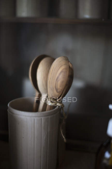 Rustic wooden spoons in ceramic crock — Stock Photo
