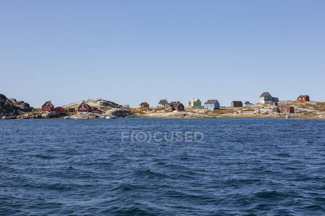 Case multicolore sulla costa soleggiata remota dell'oceano Disko Bay Groenlandia occidentale — Foto stock