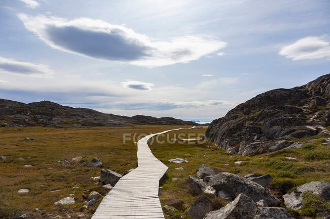 Passo a passo através da remota paisagem ensolarada e acidentada Groenlândia — Fotografia de Stock