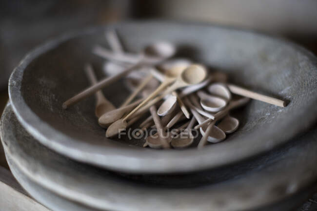 Cierre pequeñas cucharas de madera en el plato - foto de stock