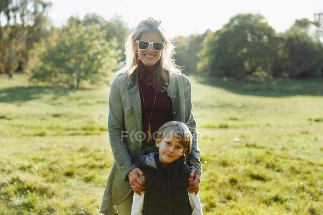 Retrato feliz mãe e filho no parque ensolarado — Fotografia de Stock
