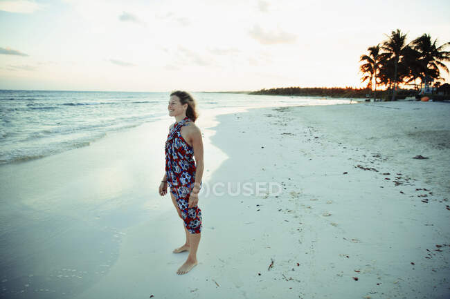 Обережна жінка в сонцезахисному одязі на спокійному березі океану Мексика — стокове фото