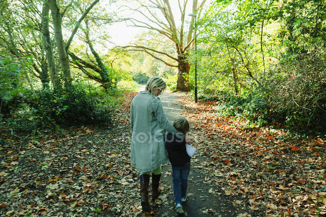 Madre e figlio passeggiano in un idilliaco parco autunnale — Foto stock